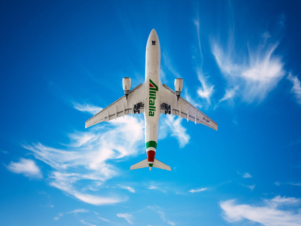 Alitalia Airbus A330 200 in new livery is flying in a blue sky